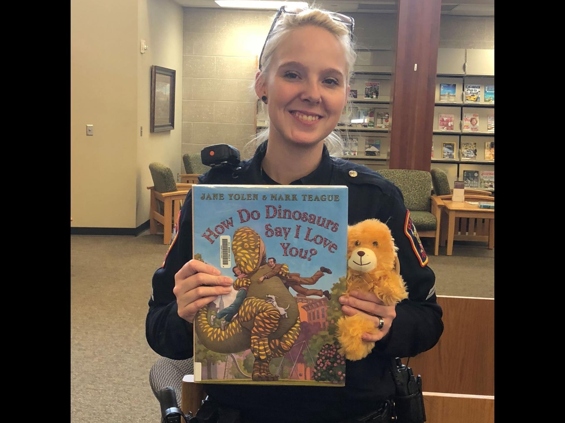 Police officer with book and stuffed animal